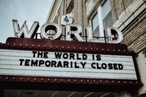 The image features a cinema marquee stating "The world is temporarily closed."